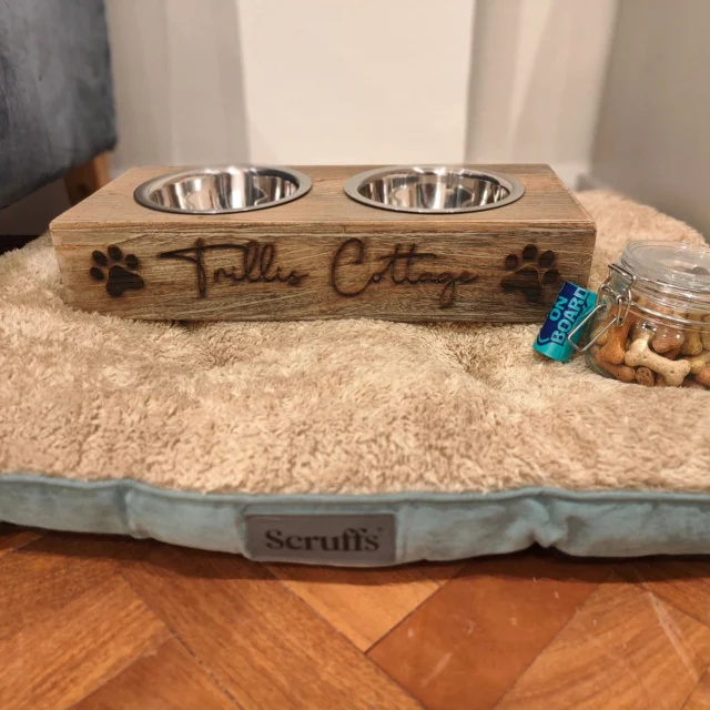 The engraved Trillis Cottage dog bowl stand on a cosy dog bed