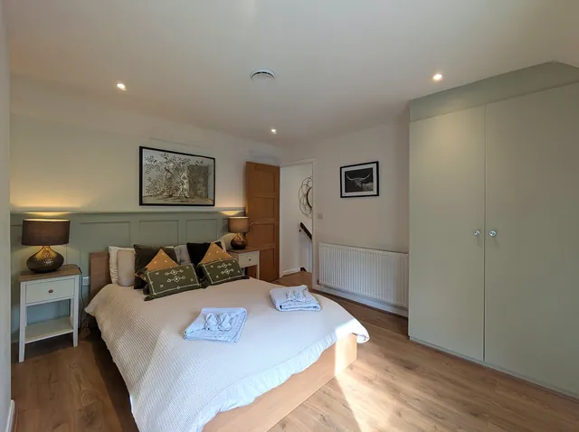 The double bedroom with a large built-in wardrobe, bedside tables and lamps