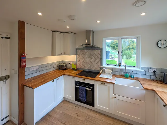 The kitchen with its stable door, oak worktops, built-in oven, hob with extractor and a window onto the garden